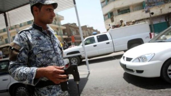 شرطي عراقي يتحقق من عدم وجود عبوات ناسفة عند حاجز في بغداد
