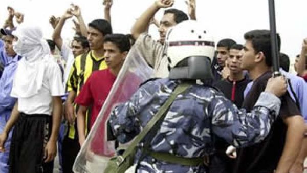 احد عناصر مكافحة الشغب يقف في مواجهة متظاهرين في النامة