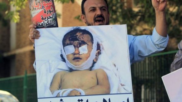 متظاهر يرفع صورة طفل قتلته القوات السورية خلال تظاهرة قام بها سوريون وسودانيون في الخرطوم للتنديد بالقمع في سوريا