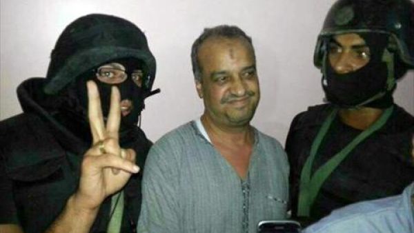 A picture distributed by the Egyptian Interior Ministry on August 29, 2013, shows senior Muslim Brotherhood politician Mohammed al-Beltagi (C) standing between two hooded policemen after his arrest in Cairo. (AFP)
