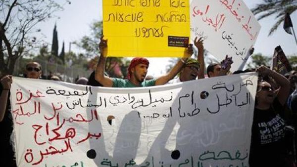 محتجون يرفعون لافتات أثناء مظاهرة في بئر السبع جنوب اسرائيل يوم الاثنين تضامنا مع بدو النقب الذين تريد الحكومة الاسرائيلية مصادرة أراضيهم
