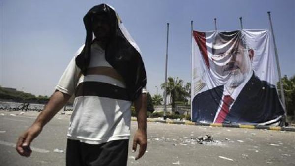 عضو في جماعة الاخوان من أنصار مرسي يمر أمام صورة ضخمة للرئيس المصري المعزول على مقربة من اعتصام رابعة العدوية يوم الأحد
