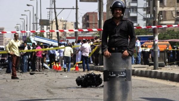 An Egyptian policeman stands guard near the scene of a bomb that targeted the convoy of Egyptian Interior Minister Mohammed Ibrahim in Cairo on September 5, 2013. An Al Qaeda inspired group have claimed responsibility for the attack. (AFP)