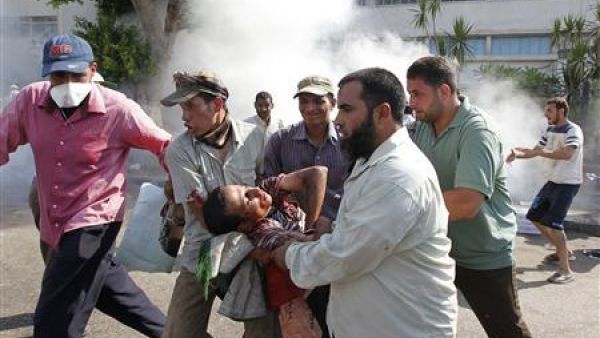 محتجون يحملون مصابا جراء اشتباكات أمام مقر الحرس الجمهوري في القاهرة
