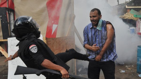رجل امن يركل احد انصار مرسي خلال فض اعتصام رابعة العدوية