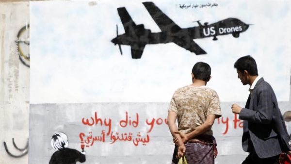 رجال ينظرون الى جدارية في صنعاء لطائرة اميركية بدون طيار 
