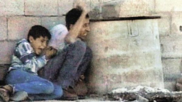 لقطة من الفيديو تظهر الشهيد محمد الدرة بجوار والده اثناء احتمائهما من الرصاص لقطة من الفيديو تظهر الشهيد محمد الدرة بجوار والده اثناء احتمائهما من الرصاص