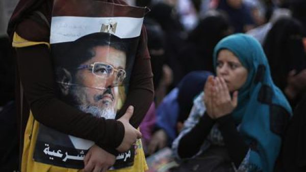 فتاة تحتضن صورة للرئيس المعزول محمد مرسي في القاهرة