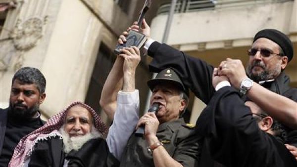 اللواء حسن الرويني يتوسط رجل دين مسيحي ورجل دين مسلم في ميدان التحرير
