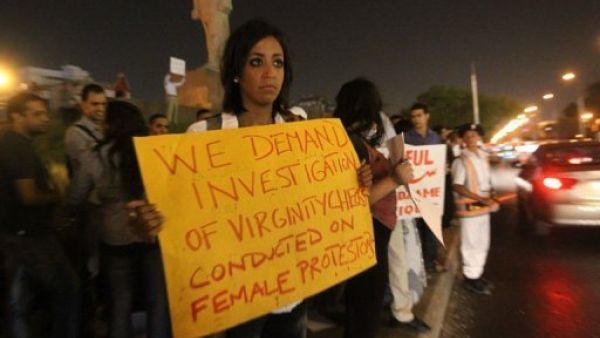 شابة تحمل لافتة ترفض اختبارات العذرية خلال تجمع في القاهرة