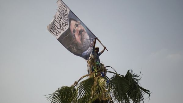 A man waves a flag picturing ousted president Mohamed Morsi on July 9, 2013. (source: GIANLUIGI GUERCIA / AFP)