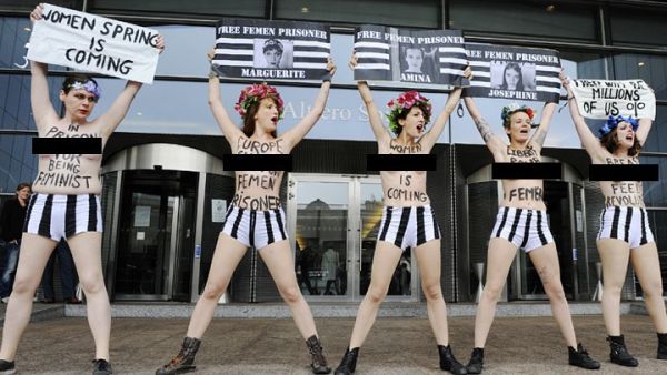 Members of the women's topless protest group Femen hold banners during a protest in front of the European Union Parliament in Brussels, to support a detained Tunisian activist and three European activists detained in Tunis. AFP photo