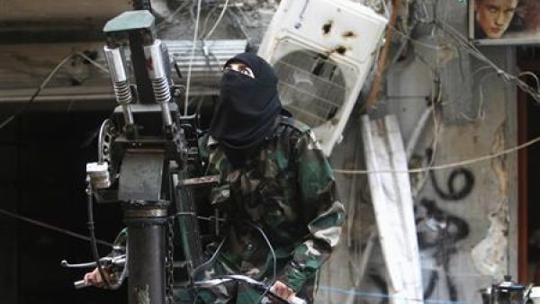 مقاتلة من المعارضة السورية تتلقى تدريبا على استخدام مدفع في حلب
