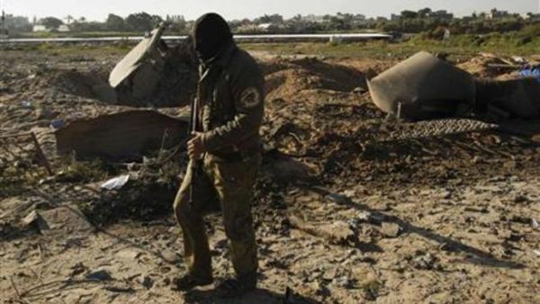 نشط فلسطيني ملثم يتفقد الاضرار التي لحقت بمعسكر تدريب بعد ضربة اسرائيلية على غزة يوم الخميس
