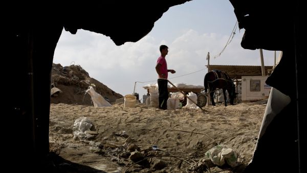  A Palestinian worker stands at the entrance to smuggling tunnels along the Gaza-Egypt border on July 19. AFP / MOHAMMED ABED