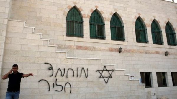 فلسطيني يتحدث في الهاتف من امام مسجد تعرض للتخريب في 5 تشرين الثاني/نوفمبر في الخليل
