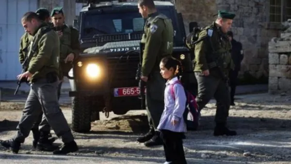 تلميذة فلسطينية تمر قرب شرطة حدود اسرائيليين في الخليل
