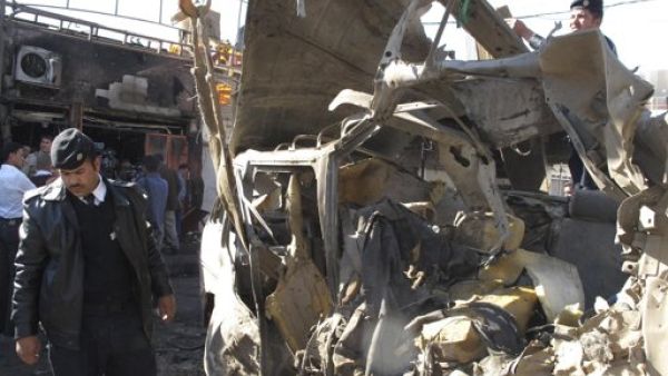 رجال امن عراقيون يتفقدون موقع احد التفجيرات في مدينة الحلة