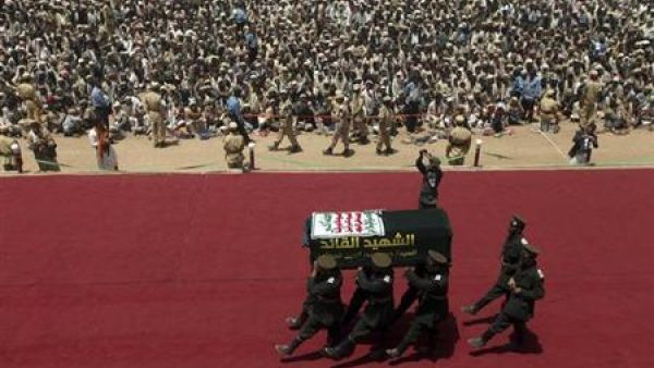 مسلحون يرتدون أزياء عسكرية شبيهة بالملابس التي ترتديها قوات الحرس الثوري الإيرانية بحملون رفات حسين الحوثي أثناء مراسم إعادة دفنه في صعدة باليمن
