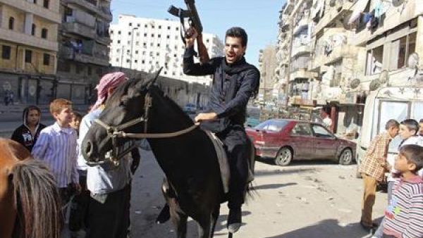 مقاتل من الجيش السوري الحر المعارض يمتطي حصانا ويمسك ببندقية في حلب في اول ايام عيد الاضحى 
