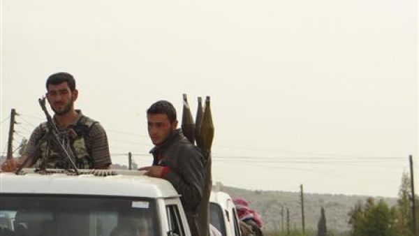 مقاتلان من الجيش السوري الحر على ظهر مركبة في ادلب
