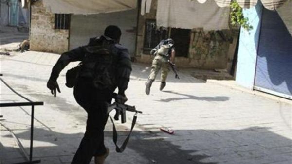 افراد من الجيش السوري الحر يركدون لتفادي نيران القناصة اثناء الاشتباكات مع قوات الاسد في ادلب
