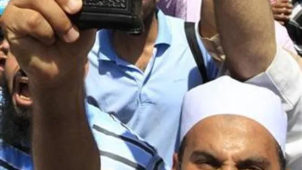 رجل يرفع مصحفا اثناء الاحتجاجات في التحرير
