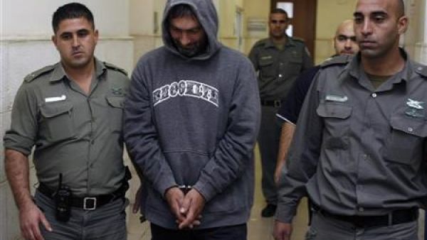 الكسندر سفيتكوفيتش في طريقه الى محكمة بالقدس بين اثنين من حراسه يوم الأربعاء
