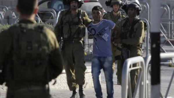 Israeli soldiers arrest a Palestinian youth in the West Bank's Qalandiya refugee camp on August 26, 2013. (AFP)