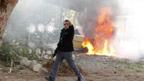 ضابط شرطة اسرائيلي يقف قبالة سيارة تحترق بعد سقوط صاروخ أطلقها نشطاء فلسطينيون من غزة على جنوب اسرائيل
