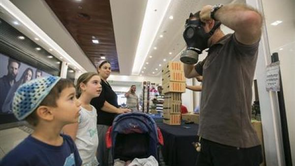 رجل يبين لبعض الاطفال كيف يستخدمون اقنعة الغاز بالقرب من القدس
