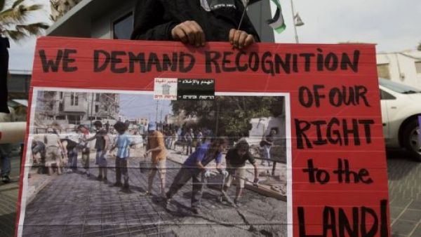 متظاهر يحمل لافتة تطالب بالاعتراف بحق الفلسطينيين في الارض