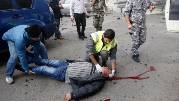 عناصر الصليب الاحمر اللبناني يحاولون اسعاف احد جرحى التفجير الذي اودى بحياة الوزير السابق محمد شطد في بيروت الجمعة
