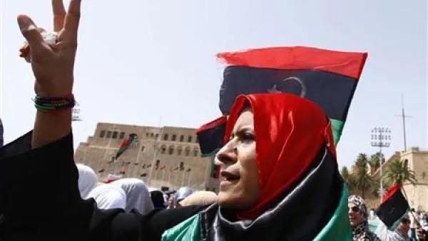 ليبية تشير بعلامة النصر أثناء أداء المصلين الصلاة في ميدان الشهداء بطرابلس
