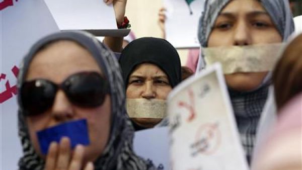 ليبيات يضعن لاصق على افواههن لدى مشاركتهن في مسيرة صامتة لدعم المرأة في طرابلس