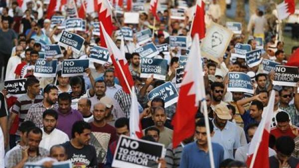 محتجون مناهضون للحكومة يحملون اعلام البحرين ولافتات كتب عليها "لا للعنف الرسمي" خلال مسيرة غربي المنامة يوم الجمعة
