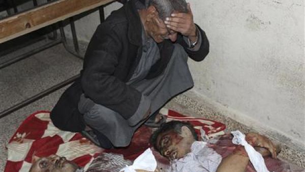 رجل يبكي فوق جثث اشخاص قتلوا بواسطة مسلحين موالين للرئيس السوري بشار الاسد