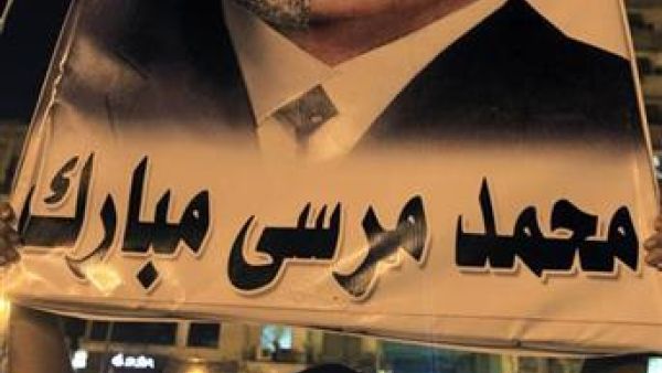 معارض للرئيس المصري محمد مرسي يحمل صورة يشبهه فيها بالرئيس المخلوع حسني مبارك خلال احتجاج في القاهرة
