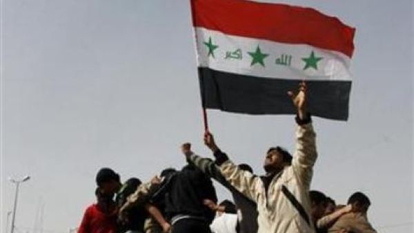 عراقيون يرفعون علم بلادهم أثناء احتجاج في الموصل 
