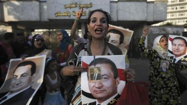 امرأة ترفع صورة حسني مبارك امام مستشفى المعادي العسكري بعد نقله إليها يوم الخميس
