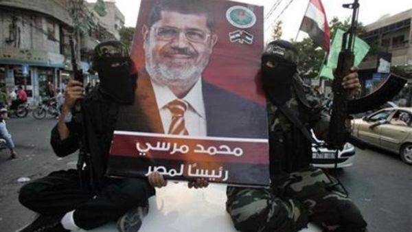 مسلحون من حماس يرفعون صورة للرئيس المصري المنتخب محمد مرسي 
