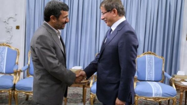 الرئيس الايراني محمود احمدي نجاد يصافح وزير الخارجية التركي احمد داود اوغلو