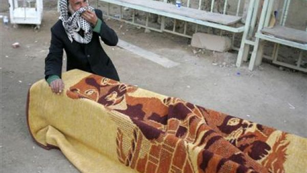 عراقي ينتحب أمام نعش أحد ضحايا تفجيرات بغداد يوم الخميس أثناء جنازته في النجف
