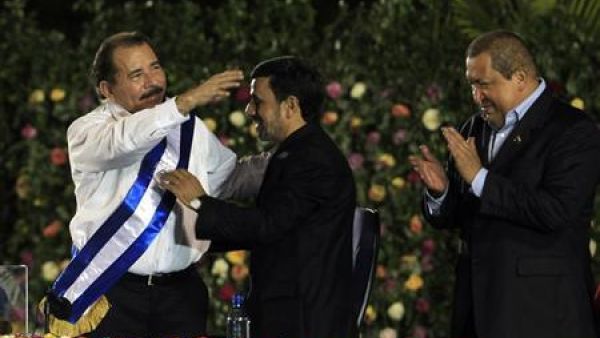 دانييل أورتيجا رئيس نيكاراجوا (الى اليسار) يتلقى التهاني من الرئيس الايراني (في الوسط) فيما يصفق رئيس فنزويلا خلال مراسم التنصيب يوم الثلاثاء
