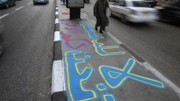 رجل يمر على رصيف مكتوب عليه لا للدستور في القاهرة
