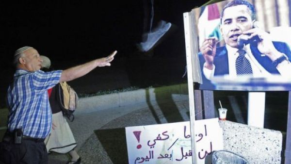 اسرائيل يوجه حذاءه الى صورة الرئيس الاميركي 