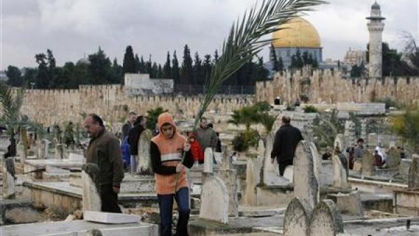 صورة أرشيفية لفلسطينيين يزورون قبور أقارب لهم في مقبرة بالقدس القديمة
