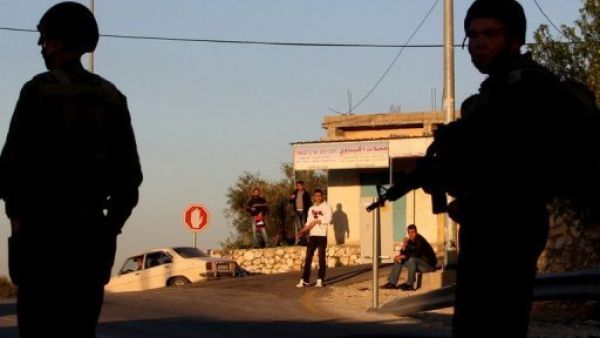 شبان فلسطينيون ينظرون الى جنود اسرائيليين في مستوطنة قرب نابلس 
