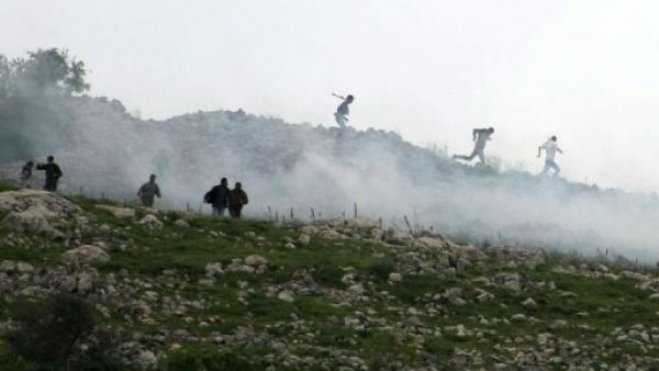 فلسطينيون يفرون الغاز المسيل للدموع الذي اطلقه الجيش الاسرائيلي خلال تظاهرة شمال الضفة
