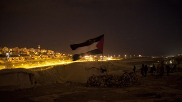 A Palestinian flag flutters at a protest camp in the controversial West Bank area known as E1 located east of Jerusalem and near the Jewish settlement of Maaleh Adumim early on Sunday. Hundreds of Israeli police dismantled the protest camp on the outskirts of Jerusalem overnight, activists and police said. (Photo: AFP / Ahmad Gharabli). 